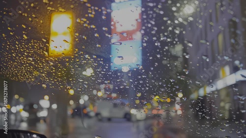 Wallpaper Mural Rain-soaked car window reveals vibrant city lights and billboards, showcasing the dynamic urban nightlife as droplets cascade down the glass surface, capturing the essence of a rainy evening Torontodigital.ca