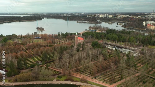 Panoramic view of Hietaniemi cemetery on the Baltic sea coast with Lapinlahti bay and Helsinki city skyline, Finnish capital urban park and historic burial ground in autumn season.