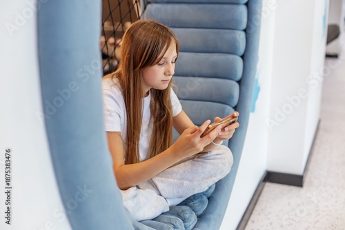 Teen girl playing video game on smartphone