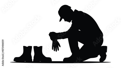 Man kneeling down putting on work gloves beside boots