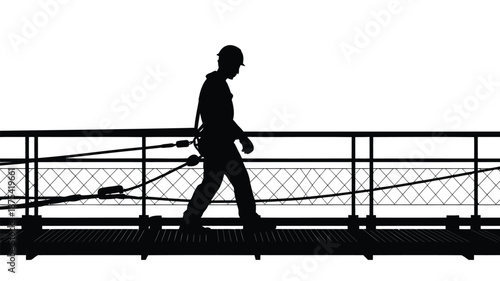 Worker in silhouette walking on industrial catwalk with safety gear