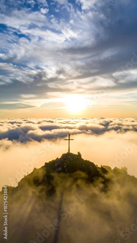 Mountain peak cross above clouds, ethereal sunlight, foggy, hazy, serene, religious, spiritual