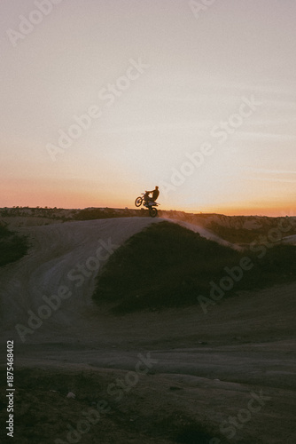 silhouette of a man riding a bike, whillie, stunt