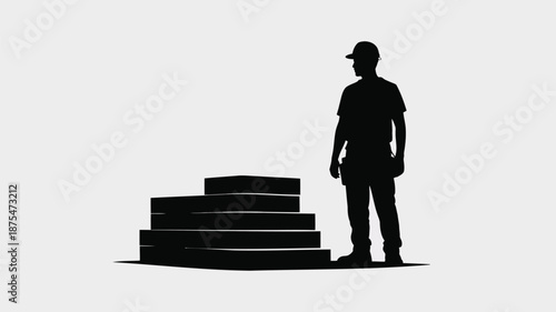 Silhouette of worker standing beside stacked boxes in warehouse