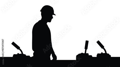 Silhouette of worker operating industrial controls