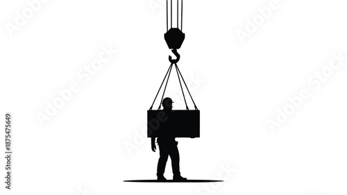 Silhouette of worker lifting heavy box with crane hook