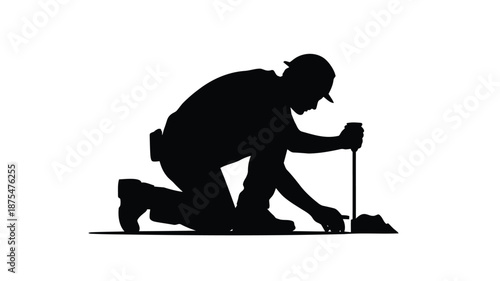 Construction worker kneeling with tool on site