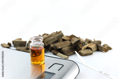 essential oil bottle , chemical beaker ,flask on digital scale white table with blotting paper, and Agarwood ud oil bottle used to blend nice scent smell for perfume and candle by perfumer laboratory