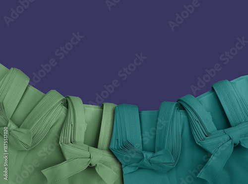 Green and blue polypropylene bag on a soft blue background. Non-woven fabric tote bag with space for text. Eco-friendly bag.