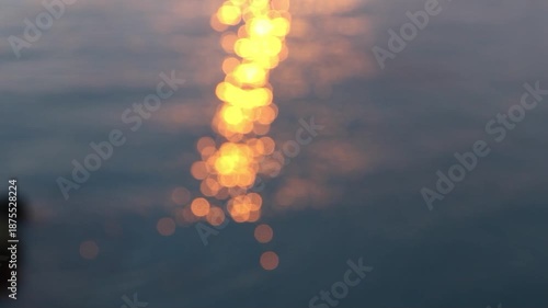 Shimmering light orbs dance in blurred ocean waves bokeh coastal sparkle evening