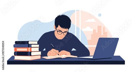 Focused male student with glasses diligently writing in a notebook while studying at a desk with a laptop and a large stack of books.