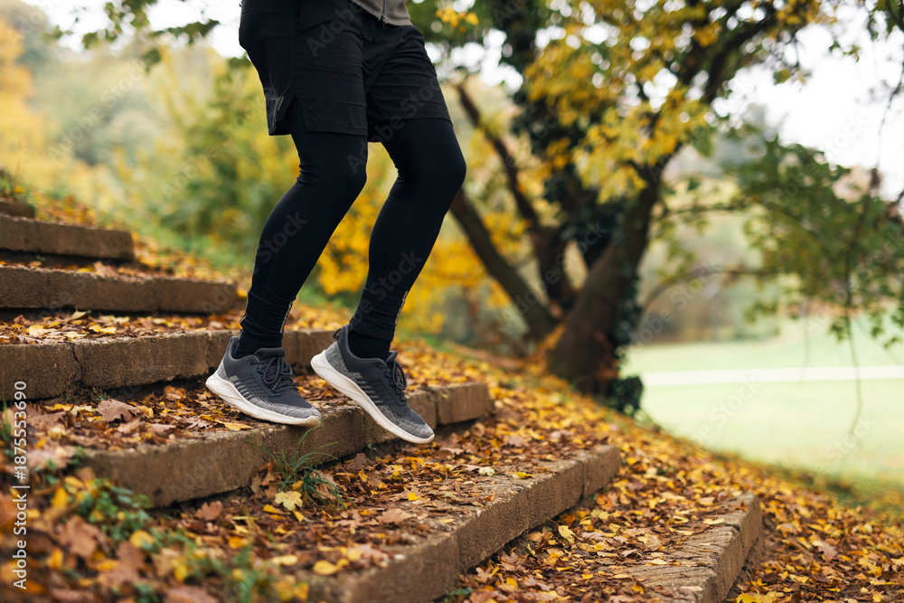 Obraz premium Man exercising on park stairs during autumn