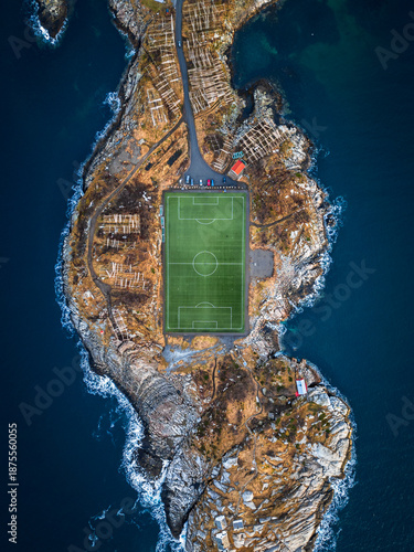 Der berühmte Fußballplatz von Henningsvær in Norwegen eingebettet in die felsige Küstenlandschaft der Lofoten zwischen Meer, Schären und Bergen aus der Vogelperspektive