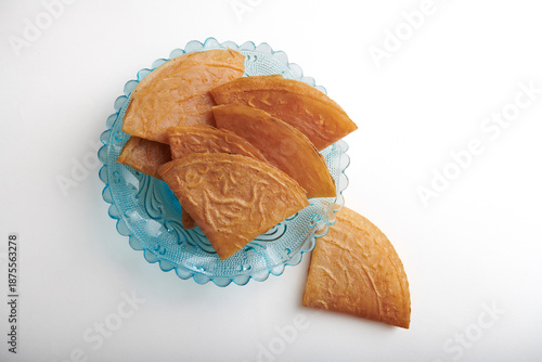 Stacked Kuih Kapit on Vintage Blue Glass Plate, Top View and isolated on white background