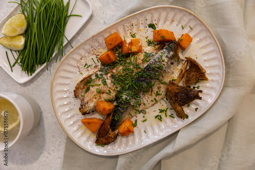 fish served with vegetables, mushrooms, carrots and fresh green onions