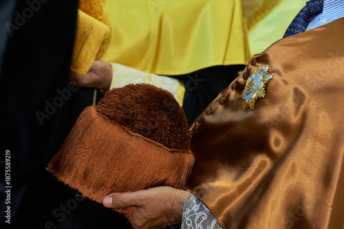Academic ceremony with graduating student holding hat