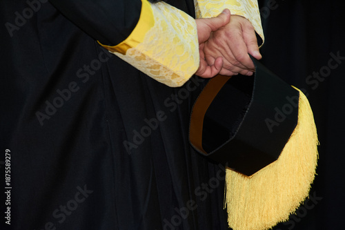 Graduate person holding academic cap with tassel