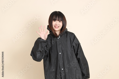 20s Asian woman wearing raincoat