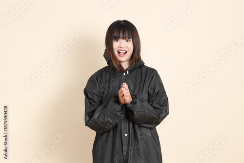 20s Asian woman wearing raincoat