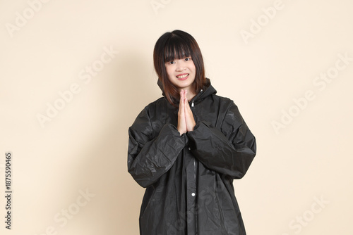 20s Asian woman wearing raincoat