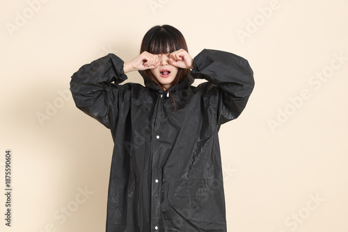 20s Asian woman wearing raincoat