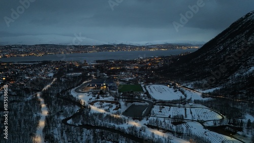 Foto Drone photography of the city of Tromsdalen, in the foreground, and the island of Tromsø in the background, during a lovely spring evening in the arctic circle, Norway