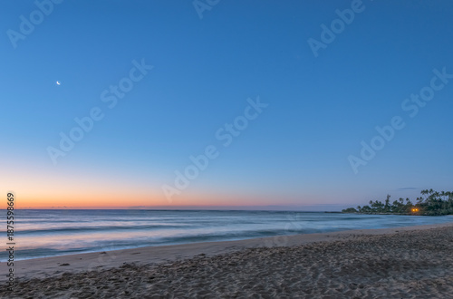 Hawaii, Kauai, Wailua Beach at dawn, the sun on the horizon, view out to sea.