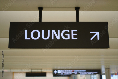 Airport lounge directional sign with white text on black background pointing to the right in travel terminal