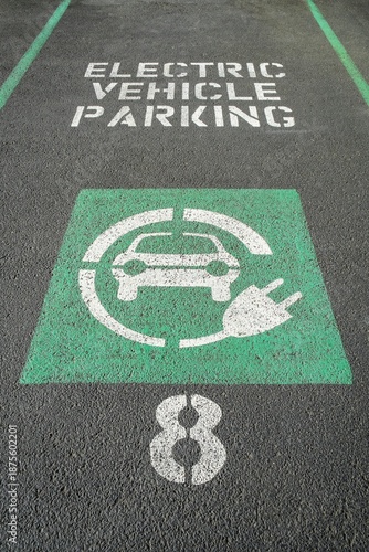 Marked parking space reserved for electric vehicles with green EV symbol and charging plug icon, Portland, Oregon.