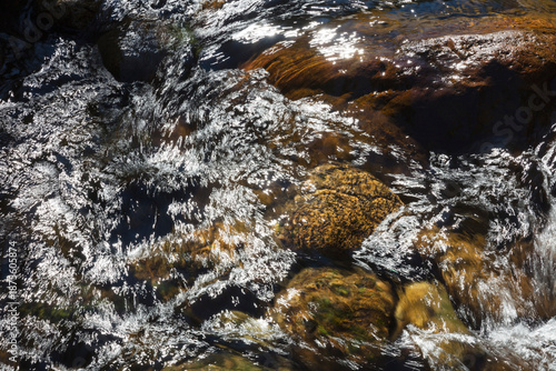 River water abstract, long exposure of river water flowing over boulders and rocks