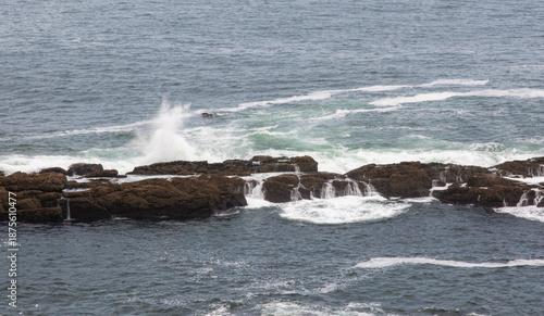 Waves crash on rocks near the Tower of Hercules in La Coruna Spain