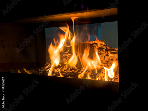 Valokuva Modern freestanding wood burning stove with glowing flames and logs providing th