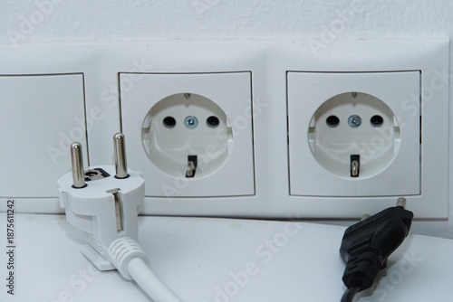 Stecker liegen vor einer Steckdose - Nahaufnahme