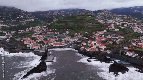Overcast coastal village with terraced fields and misty shoreline