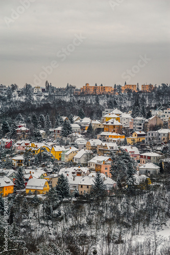 Panoramic view of the city on hills covered with snow under overcast winter sky