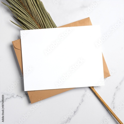 A pristine white card rests inside a rustic brown envelope, surrounded by delicate green leaves, creating a serene and inviting composition.