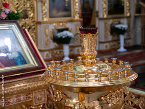 Fototapeta Ornate golden liturgical lampada stand with red glass oil lamp inside orthodox c