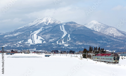 Wallpaper Mural Winter scene of a local train of JR Ban'etsu West Line traveling from Inawashiro to Kawageta through the country field covered by deep snow & Mount Bandai dominating the background in Fukushima, Japan Torontodigital.ca