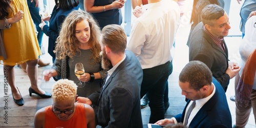 Diverse group at a social event, mingling and networking. People chatting, holding drinks, and engaging in conversation at a lively gathering. Diverse people mingle at a social event.