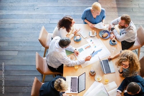 Foto Group of professionals in a meeting, discussing graphs