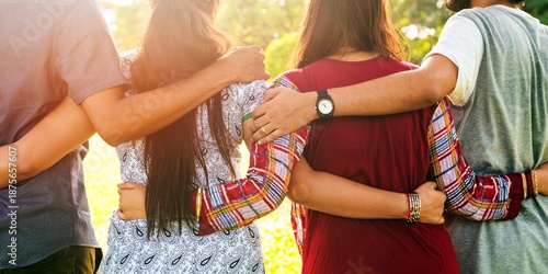Tablou pe pânză Group of diverse friends embracing outdoors, arms around each other, showing unity and friendship