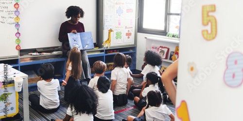 Fotografie A teacher reads to a diverse group of young students in a classroom