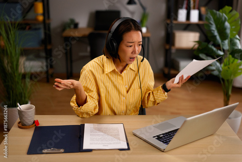 Asian woman experiencing stress during video call meeting