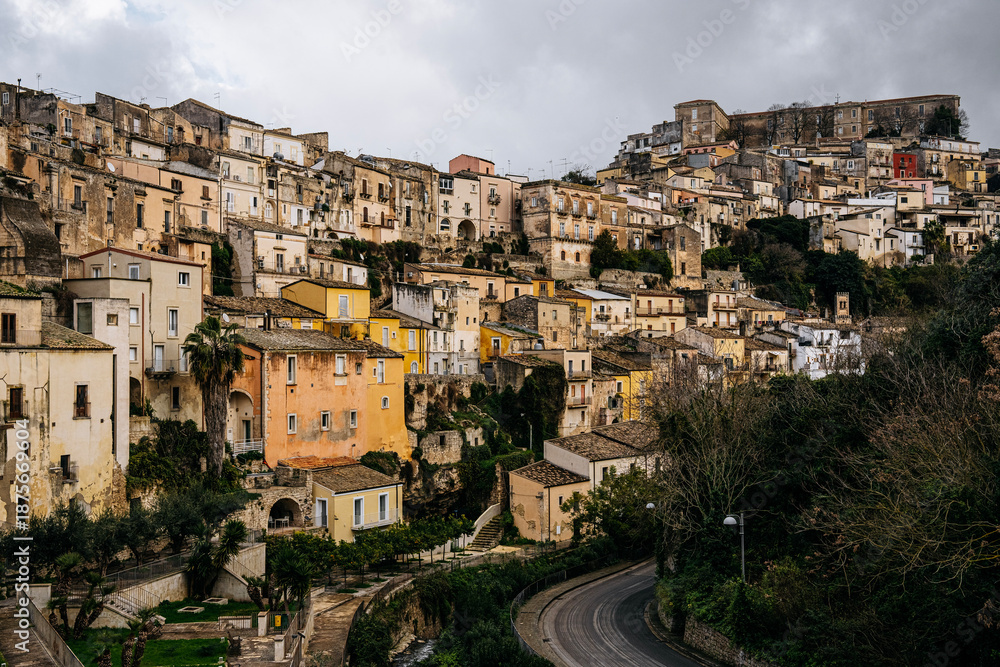 Fototapeta premium Hilltop City Of Ragusa In Sicily Under Overcast Sky: Historic Stone Buildings And Dense Urban Landscape In Soft Diffused Light And Hazy Weather