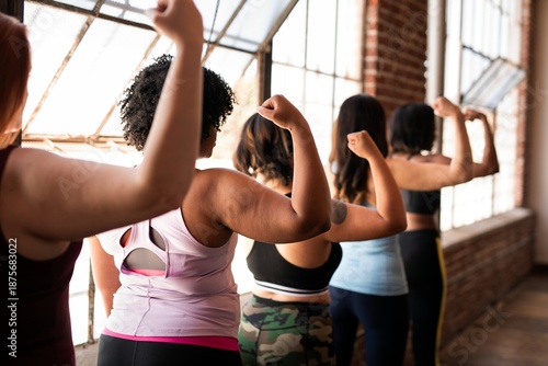 Schilderij op canvas Four women, diverse ethnicities, flexing arms in a gym