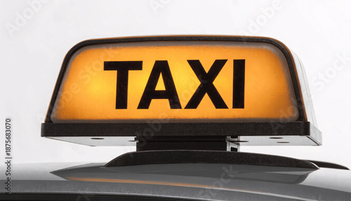 Bright yellow taxi roof light sign with bold black text on vehicle