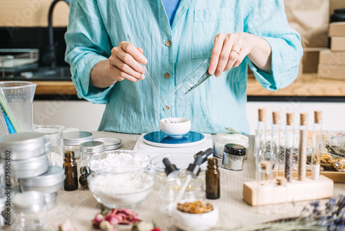 Принти на полотні Hands add botanical powder to bowl on digital scale surrounded by laboratory tools and organic components