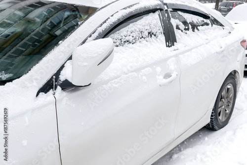 Fresh snow ice layer on windscreen,windshield,hood of car. cleaning snow after snowstorm,heavy blizzard from car in cold winter
