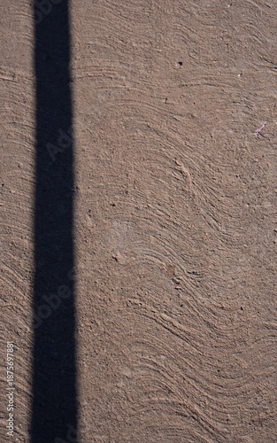 Peach colored textured cement or concrete wall with one vertical shadow line dividing the blank space into two empty spaces for type vertical backdrop background or wallpaper