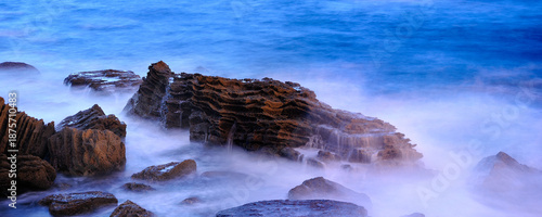 Ocean waves crashing on rugged coastal rocks